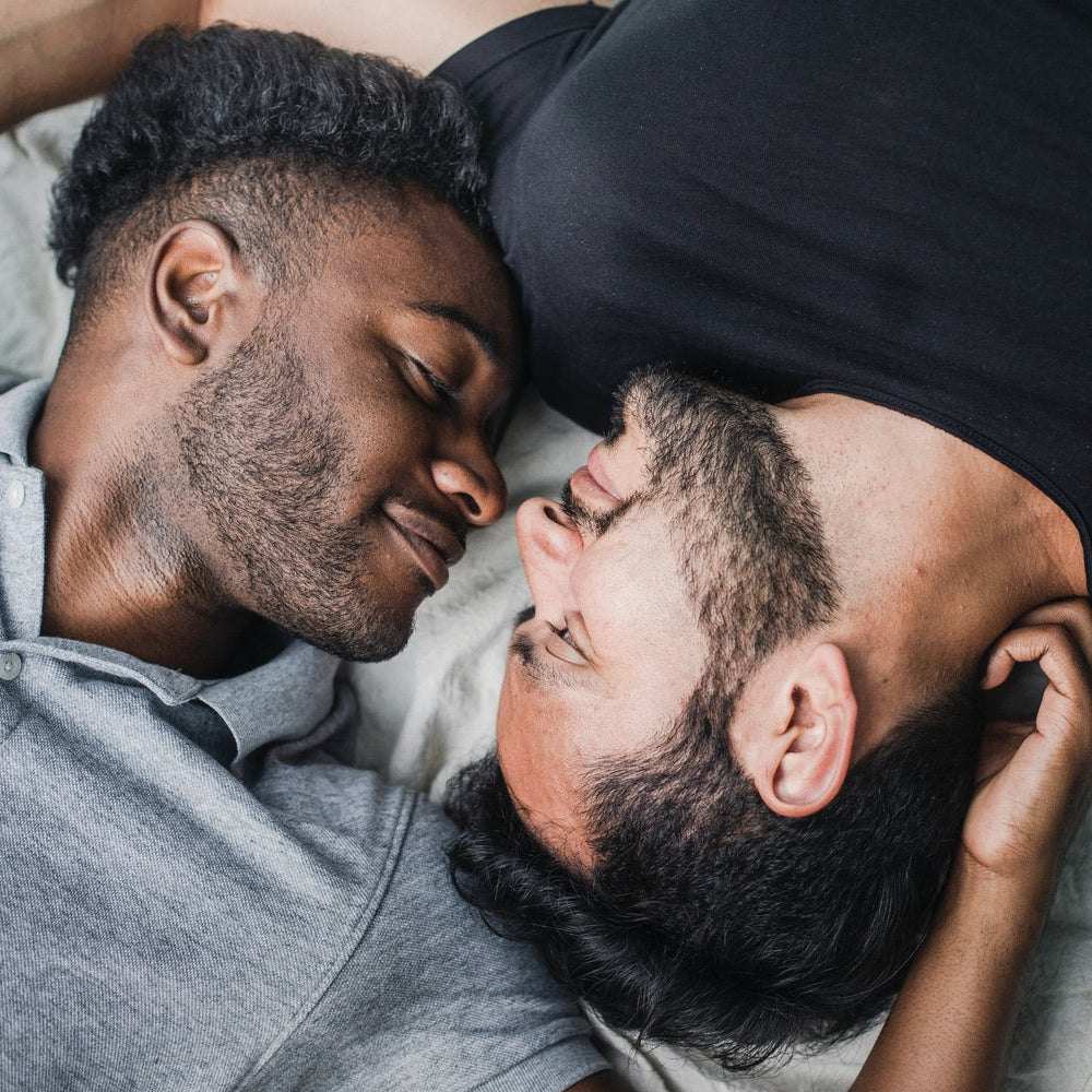 Two people facing each other in bed