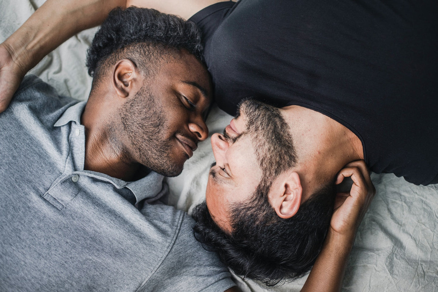 Two people facing each other in bed